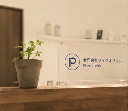 フィジオリフレの受付。ロゴプレートと観葉植物